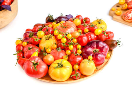 Different tomatoes on white. Vegetables of different varietiesの写真素材