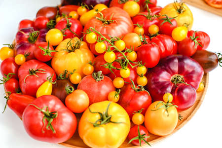 Different tomatoes on white. Vegetables of different varietiesの写真素材