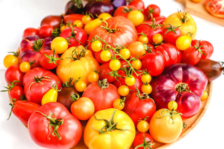 Different tomatoes on white. Vegetables of different varietiesの写真素材