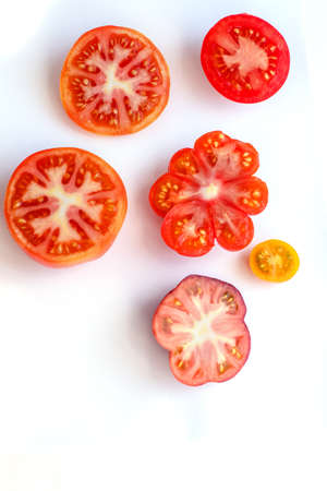 Different tomatoes on white. Vegetables of different varietiesの写真素材