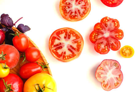 Different tomatoes on white. Vegetables of different varietiesの写真素材