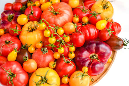 Different tomatoes on white. Vegetables of different varietiesの写真素材