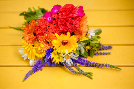 A multi-colored bouquet of wildflowers. Chamomile, cornflowers, calendula, poppy seeds. Flowers are like a rainbow. Bright summer bouquet. spring flowering.の写真素材