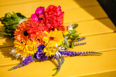 A multi-colored bouquet of wildflowers. Chamomile, cornflowers, calendula, poppy seeds. Flowers are like a rainbow. Bright summer bouquet. spring flowering.の写真素材