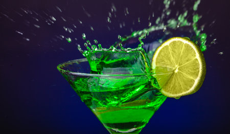Green drink in a glass. Green water or limnad. A splash of green liquid similar to absinthe. Alcohol and alcoholism.の写真素材