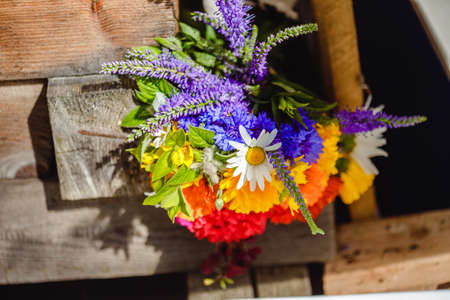 A multi-colored bouquet of wildflowers. Chamomile, cornflowers, calendula, poppy seeds. Flowers are like a rainbow. Bright summer bouquet. spring flowering.の写真素材
