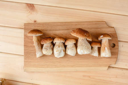 Mushrooms on a wooden background. Boiled mushroom on a cutting board. Healthy vegetarian food....