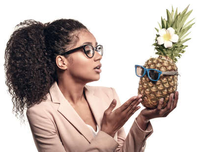 Model with pineapple in hands. African American Girl with Exotic Fruit. Cheerful woman with a smile relaxing on vacation. Image about summer time, smile and restの写真素材