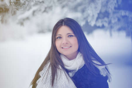 Beautiful girl on the street in winter. Woman outdoors against the backdrop of a magical winter landscape.の写真素材