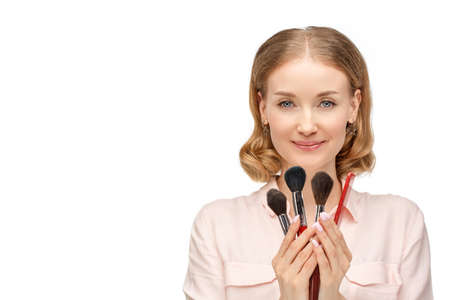 Make-up stylist, hairdresser on a white background. Girl with brushes and a comb in her hands.の写真素材