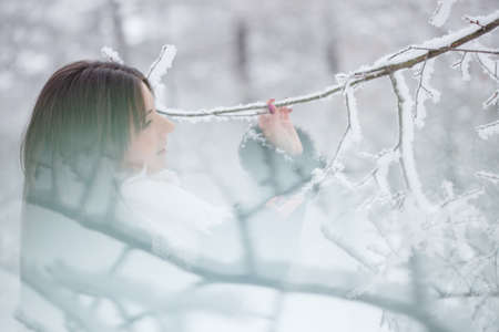 Beautiful girl on the street in winter. Woman outdoors against the backdrop of a magical winter landscape.の写真素材