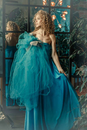 Elegant woman in a long vintage blue dress. Fabulous girl. Cover of a love story.の写真素材