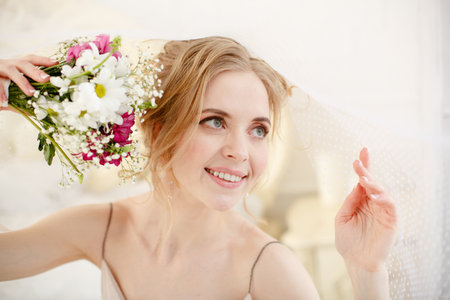 Bride with wedding flowers bouquet. Woman in wedding dress. Young fashion model with perfect skin, make up and Beautiful Hairstyle. happy day. Marriage.の写真素材