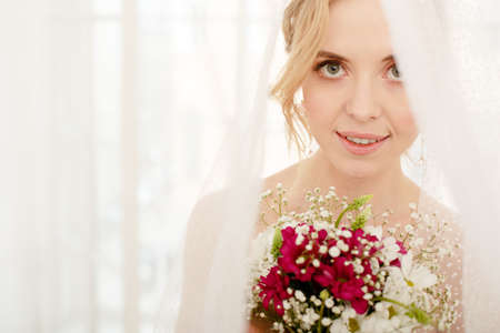 Bride with wedding flowers bouquet. Woman in wedding dress. Young fashion model with perfect skin, make up and Beautiful Hairstyle. happy day. Marriage.の写真素材
