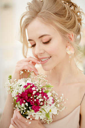 Bride with wedding flowers bouquet. Woman in wedding dress. Young fashion model with perfect skin, make up and Beautiful Hairstyle. happy day. Marriage.の写真素材