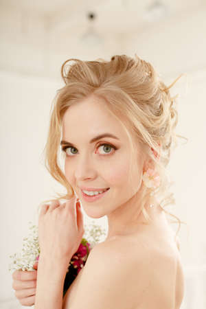 Bride with wedding flowers bouquet. Woman in wedding dress. Young fashion model with perfect skin, make up and Beautiful Hairstyle. happy day. Marriage.の写真素材