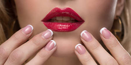 Female lips painted with red lipstick. Sexy lips of a woman. Makeup for a girlの写真素材