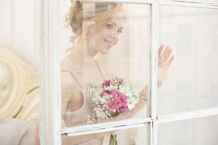 Bride with wedding flowers bouquet. Woman in wedding dress. Young fashion model with perfect skin, make up and Beautiful Hairstyle. happy day. Marriage.の写真素材
