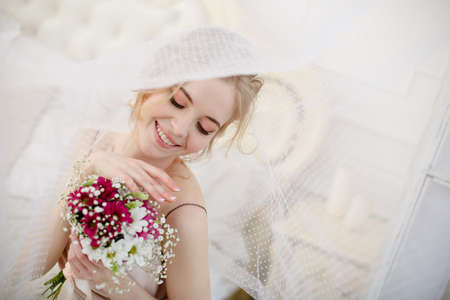 Bride with wedding flowers bouquet. Woman in wedding dress. Young fashion model with perfect skin, make up and Beautiful Hairstyle. happy day. Marriage.の写真素材