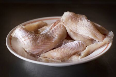 Fresh frozen hake fish on plateの写真素材
