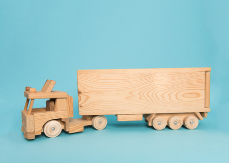 Wooden toy truck on a blue background with space for text as a birth announcement card or birthday cardの写真素材
