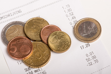 Different euro coins lying on a receipt ticketの写真素材