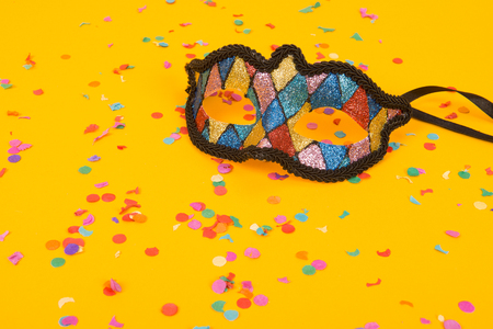 Venetian colorful mask on a yellow background with confettiの写真素材