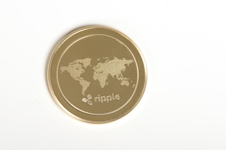 Golden Ripple coin on a white backgroundの写真素材