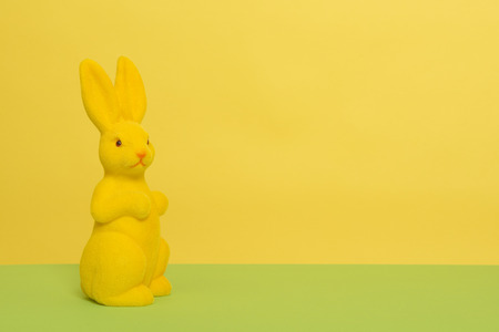 Yellow decoration easter bunny on a yellow and green background with copy spaceの写真素材