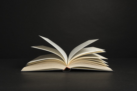 Open book with pages on a black backgroundの写真素材
