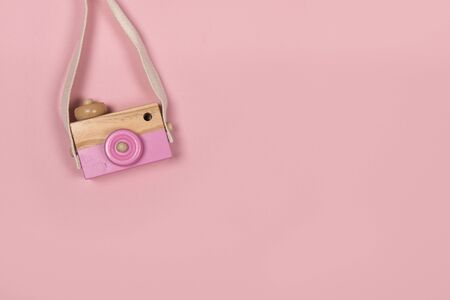 Wooden toy camera on a pink background with copy spaceの写真素材