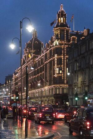 London, UK - December 2017: Building of Harrods store in Brompton Road in Knightsbridge, London by night during a rainy evening in a vertical imageのeditorial素材