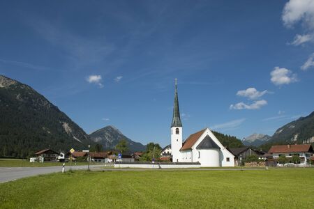 Graswang, Bavaria, Germany - July 17, 2019; Picturesque white church in a sunny mountain landscape in the south of Germanyのeditorial素材