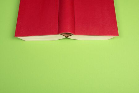 Cover of a red book on a green background with space for copyの写真素材