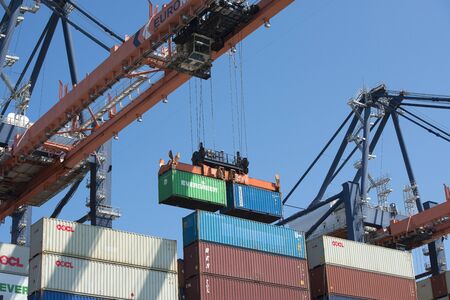 Rotterdam, The Netherlands - July 30, 3019: Containers being moved after being disembarked on a...