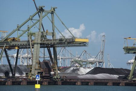 Netherlands, Rotterdam - July 30, 2019; Coal terminal wih big industrial cranes for handling coal...