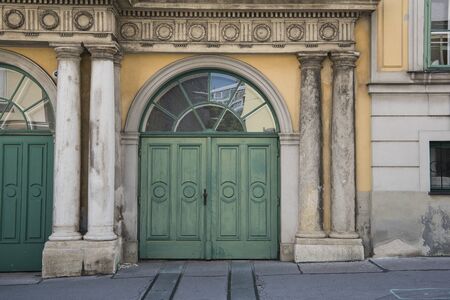 Old wooden green door and antique yellow limestone wall for an antique urban backgroundのeditorial素材
