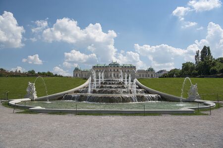 Vienna, Austria - June 5, 2019; A fountain looking out at the upper Belvedere palace, one of the two baroque Palaces of Belvedere where art exhibitions are being held and a popular tourist destination in Viennaのeditorial素材