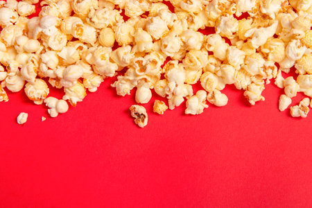 Popcorn on a red background as a concept for movies with space for copyの写真素材