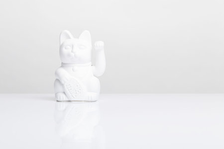 White Maneki Neko cat on a white background with space for copyの写真素材