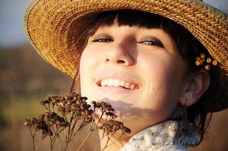 Smiling rural girl with straw hatの写真素材