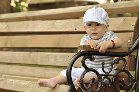 Little child on bank in the parc  の写真素材