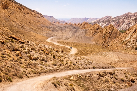 A Car Leaving Plumes of Dust Driving through the Kodachrome Basin State Park, Utah on a hot summer dayの写真素材