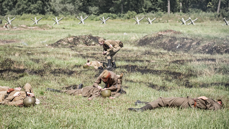 STARY TEKOV, SLOVAKIA - JULY 26,2014:  Nurses treating injured soldiers on a battlefield during reconstruction of a World War II fight.のeditorial素材