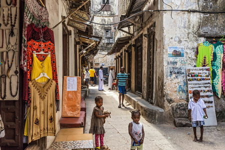 STONE TOWN, ZANZIBAR - OCTOBER 24, 2014: Local people on a typical narrow street in Stone Town. Stone Town is the old part of Zanzibar City, the capital of Zanzibar, Tanzania.のeditorial素材