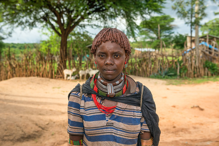 TURMI, OMO VALLEY, ETHIOPIA - MAY 5, 2015: Portrait of a woman from the Hamar tribe in south Ethiopia. Married hamar women apply red clay to their hair and fashion it into long tufts.のeditorial素材