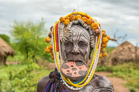 OMO VALLEY, ETHIOPIA - MAY 7, 2015 : Woman from the african tribe Mursi with big lip plate in her village.のeditorial素材