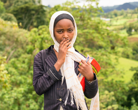 ADDIS ABABA, ETHIOPIA - MAY 4, 2015 : Young ethiopian schoolgirl carrying her exercise books.のeditorial素材