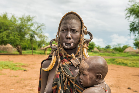 OMO VALLEY, ETHIOPIA - MAY 7, 2015 : Woman from the african tribe Mursi with  her babyのeditorial素材