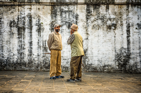 KATHMANDU, NEPAL - OCTOBER 21, 2015 : Two aged men discuss in the street at Pashupatinath Temple complexのeditorial素材